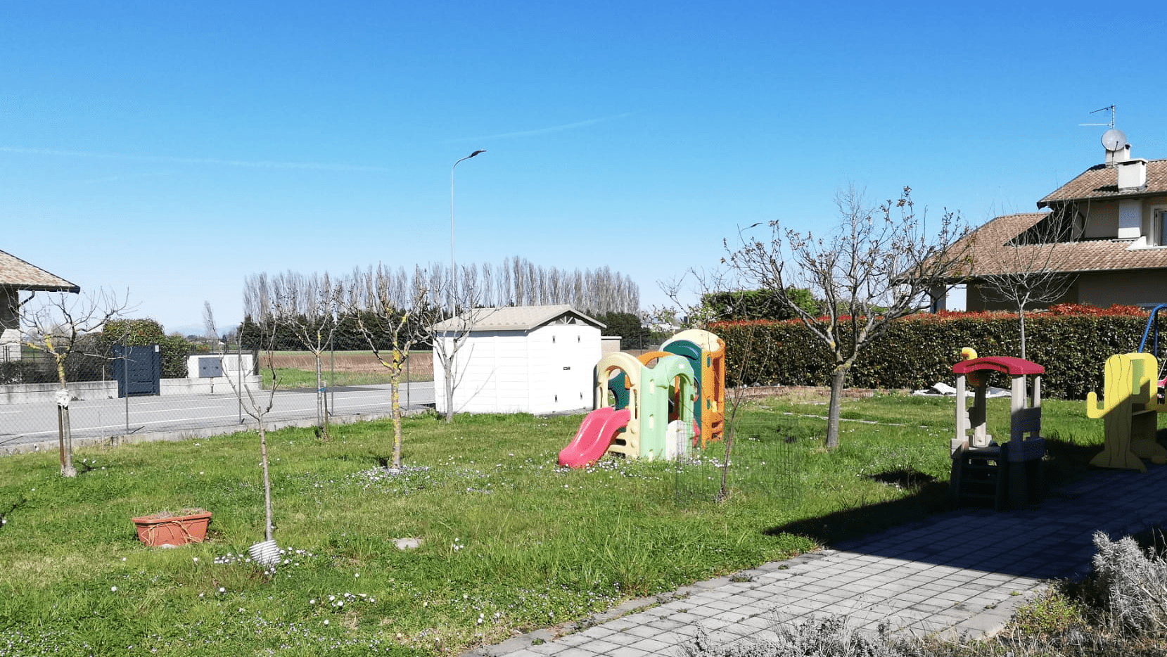 Giardino posteriore con zona attrezzata ad orto e arredi per l'attività didattica all'aperto